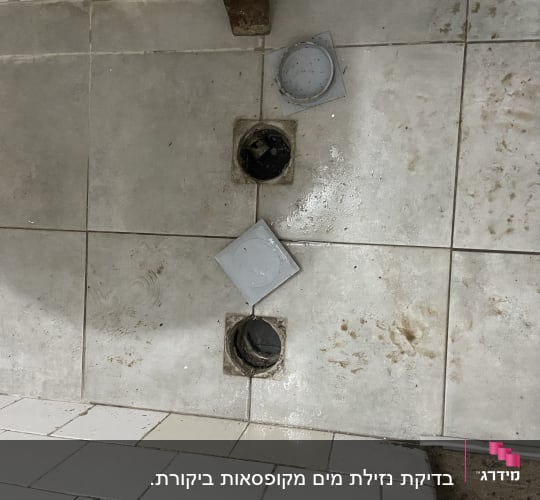 פתחי ניקוז פתוחים ברצפה עם מכסים מונחים בצד